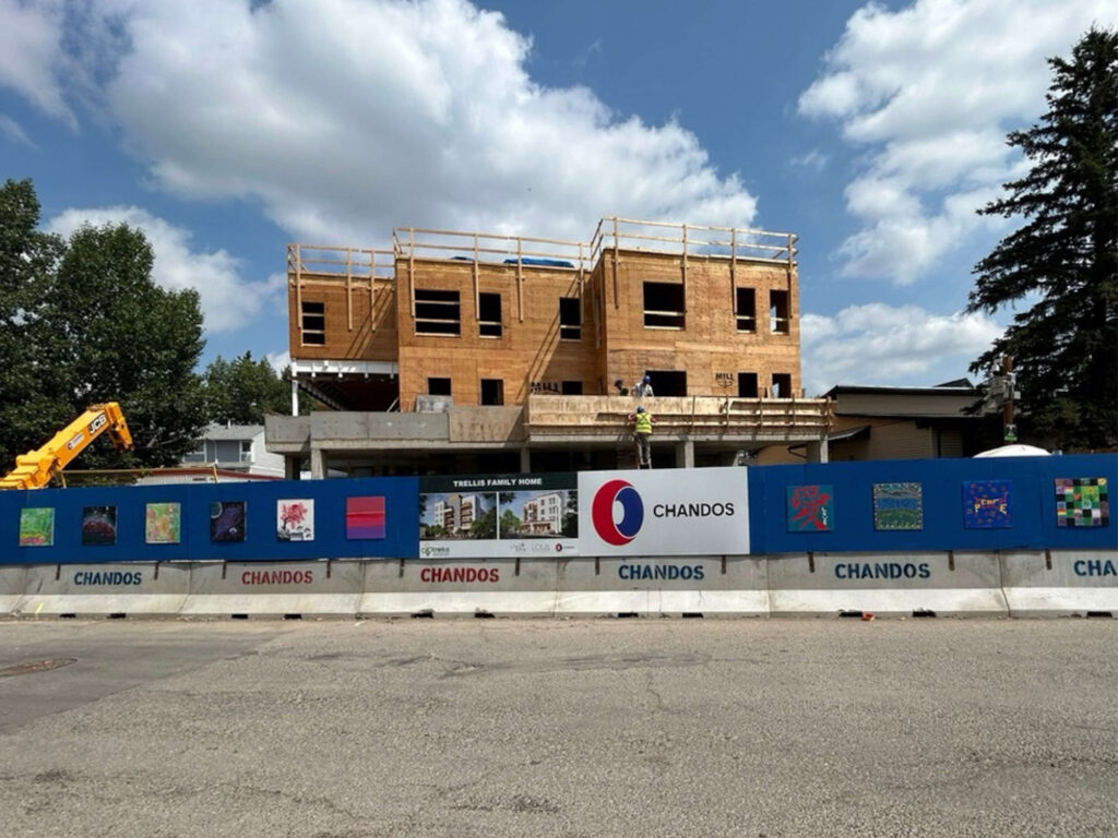 Photograph of A New Home for Families, project by Trellis Society, in construction. Artwork is hung on the hoarding around the construction site.